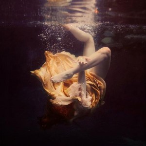 goldfish woman drowning under water orange dress