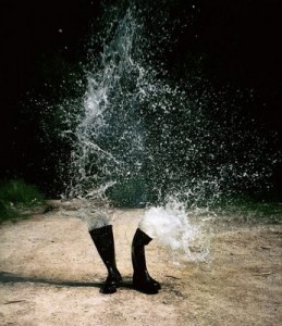 black Wellington boots water splashing rain sand